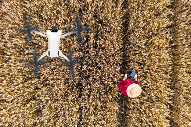 An aerial view of a drone spraying fertilizer on a field of crops, demonstrating precision agriculture techniques. The image highlights the drone's ability to apply inputs evenly and efficiently.