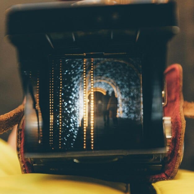 A split-screen showing on one side a classic film set with traditional equipment, and on the other side a modern, minimalist set with digital equipment, representing the blend of old and new techniques in independent filmmaking.