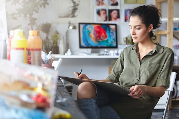 An artist thoughtfully composing an email submission to a gallery on a laptop, with a gallery brochure and portfolio nearby.