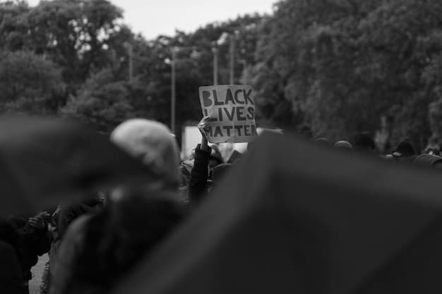 A black and white photograph of protesters marching during the Civil Rights Movement, holding signs with slogans advocating for equality and desegregation. The image captures the determination and resilience of the activists, with a focus on the emotional expressions on their faces.