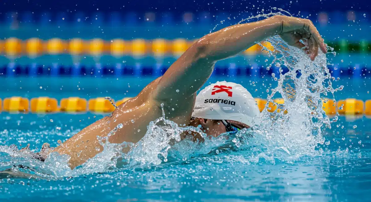 Swimmer breaking water surface during record-breaking Olympic race